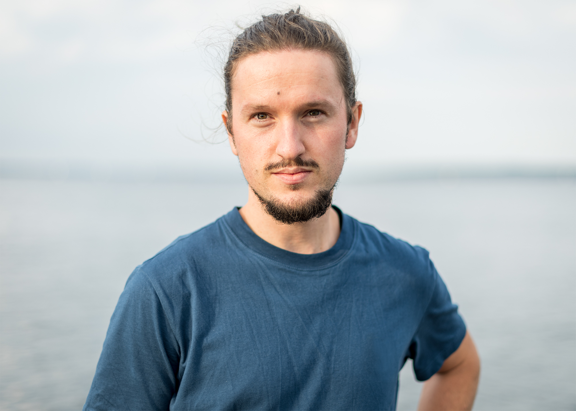 © Paul David Heckhausen ein Mann im blauen T-Shirt steht vor dem Meer
