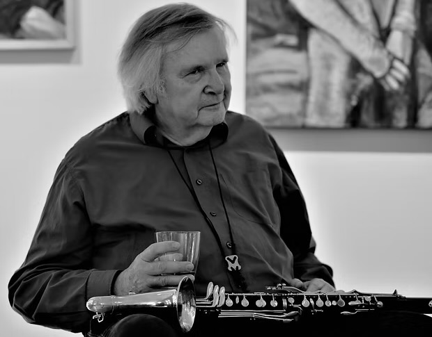 @ Manfred Klement schwarz-weiß Aufnahmen von einem Mann mit einer Bassklarinette auf dem Schoß