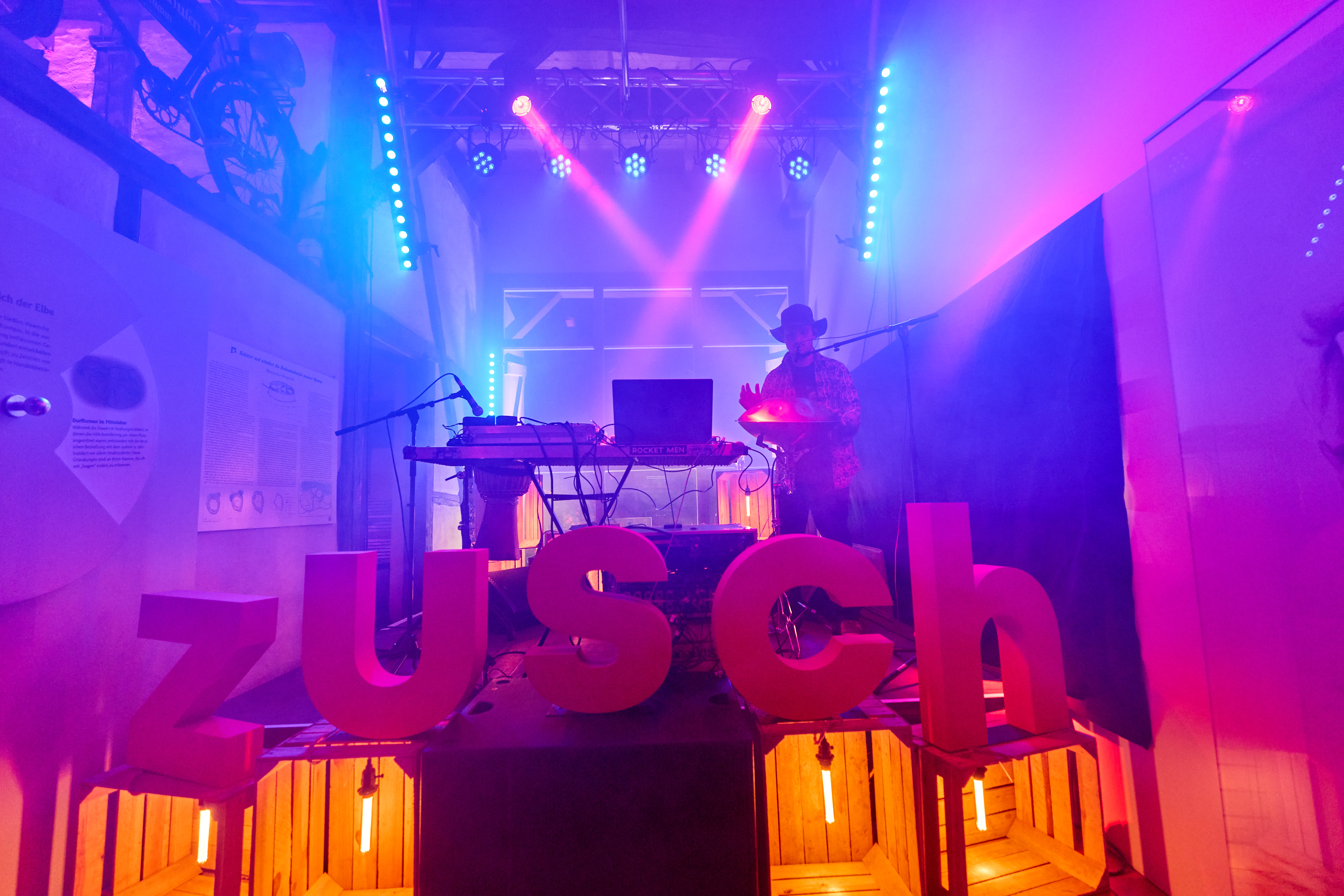 © Oliver Borchert Ein DJ steht auf einer bunt beleuchteten Bühne