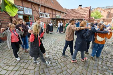 © Oliver Borchert die Teilnehmenden üben einen historischen Rundtanz auf dem Museumshof