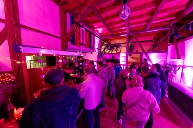 © Oliver Borchert Menschen stehen an der Bar im pink beleuchteten Museum