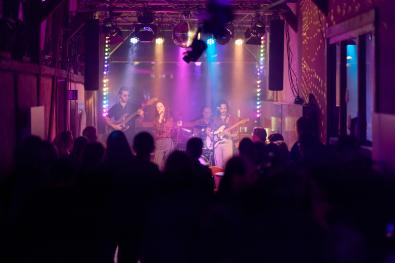 © Oliver Borchert eine Band musiziert auf einer bunt beleuchteten Bühne