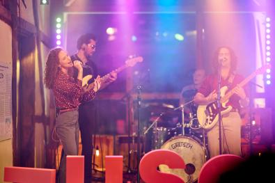 © Oliver Borchert eine Band musiziert auf einer bunt beleuchteten Bühne