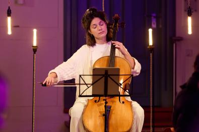 © Oliver Borchert Eine Cellistin sitz zwischen Lampen und spielt mit geschlossenen Augen Cello
