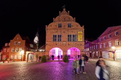 © Oliver Borchert Menschen laufen über den Marktplatz von Gadebusch bei Nacht